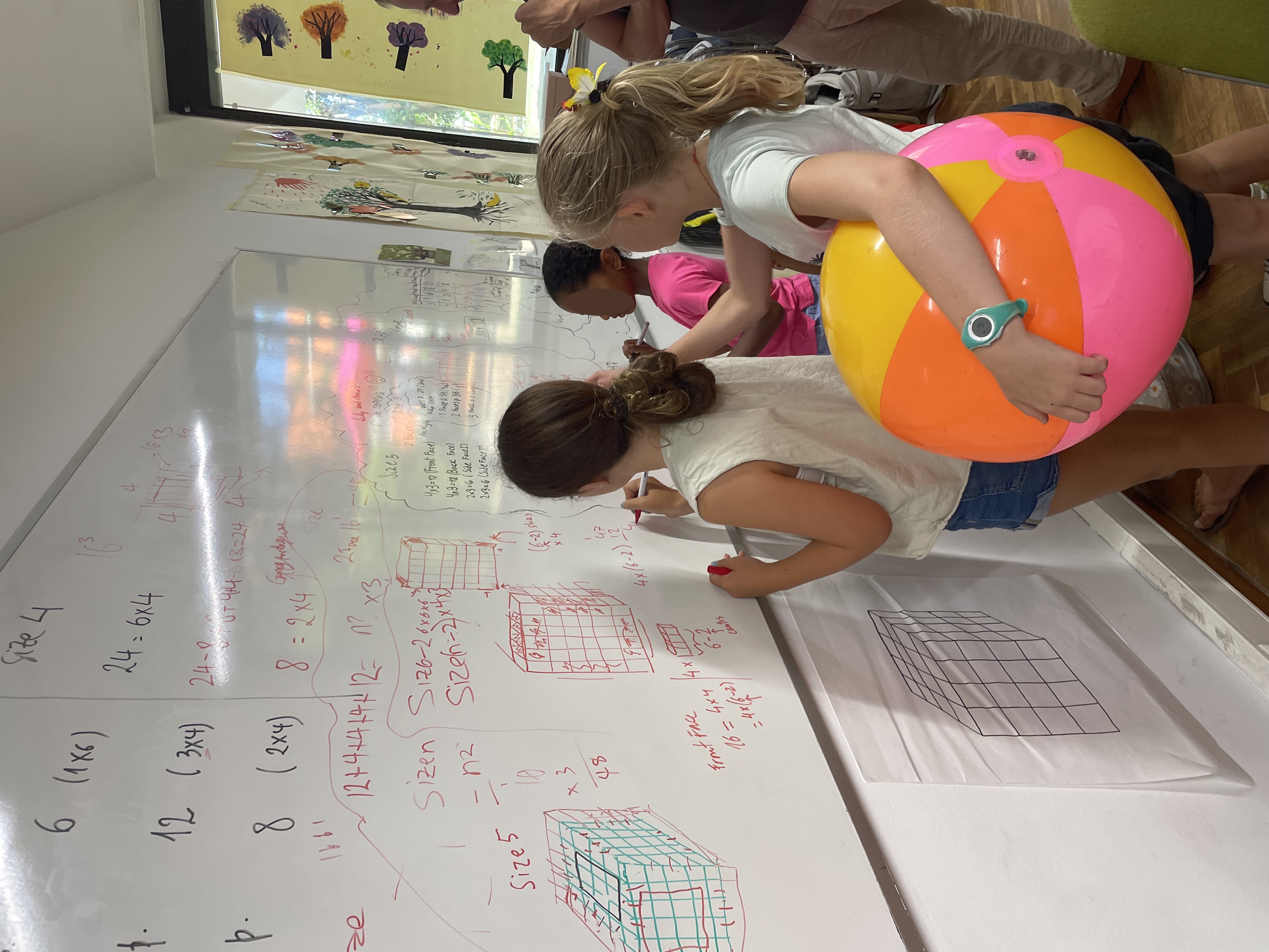 Students writing maths on large whiteboard